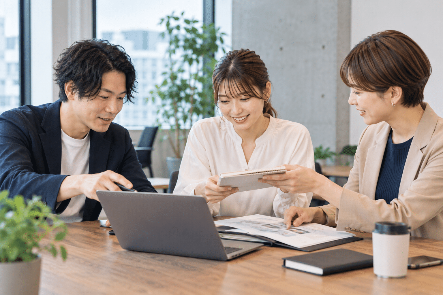 日本人の男女3人が担当交代の引継ぎミーティングを行う
