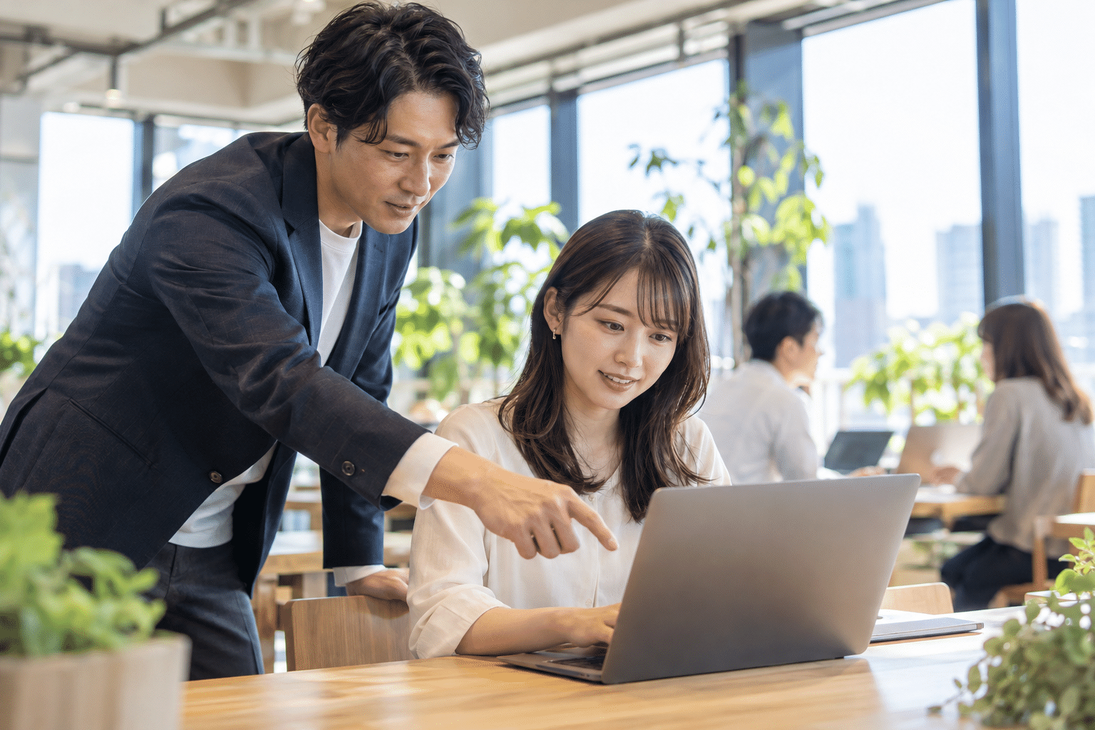 講師が受講者のノートPC作業を横から見てアドバイスする